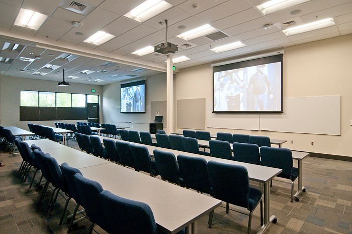 Training room with dual projection screens and ceiling audio, installed by Projectus